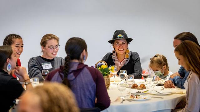 A photo of a group of people seated at a table with plates and water glasses.