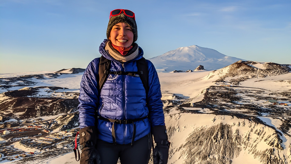 Initiative participant bundled up, standing at the top of Observation Hill in Antarctica